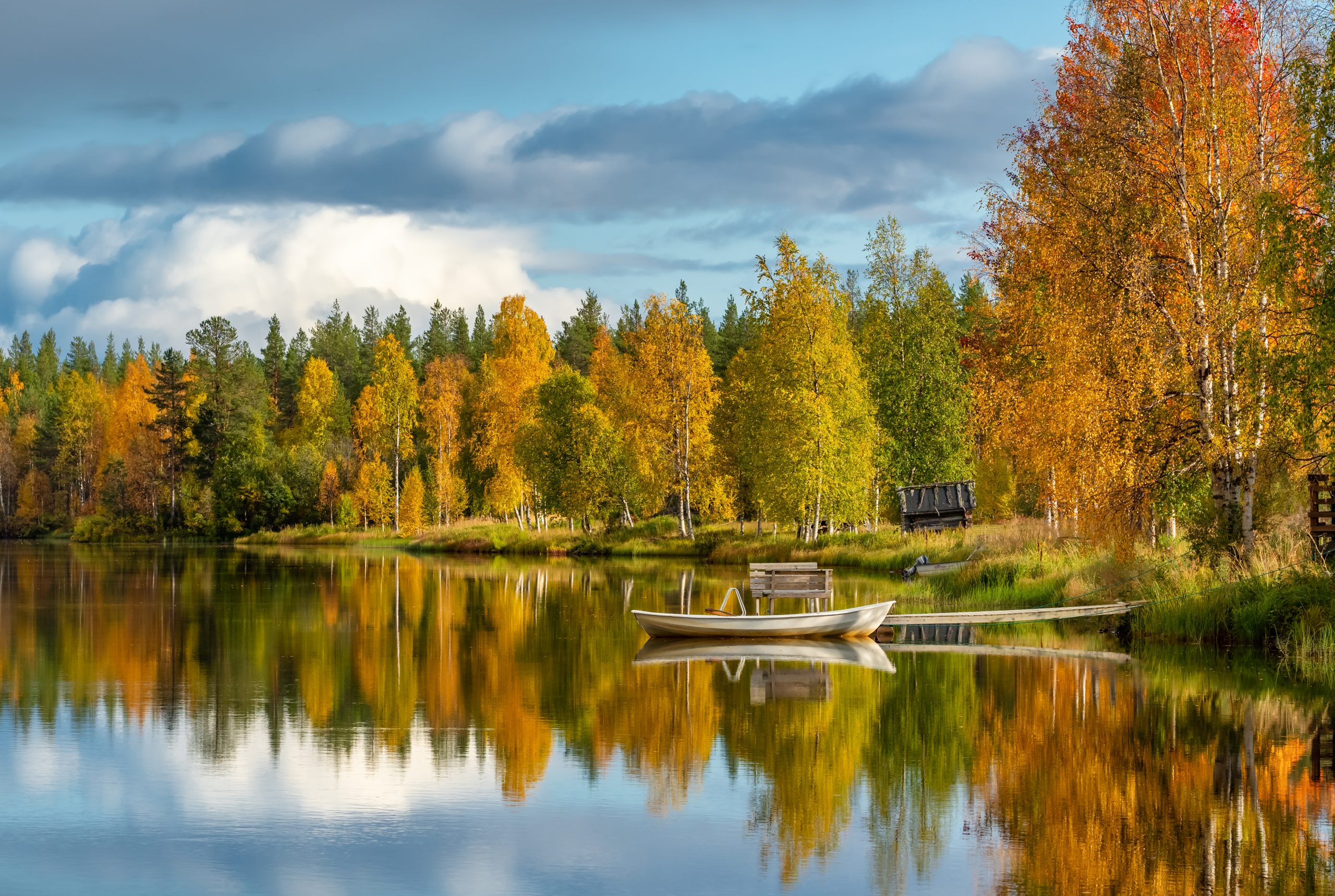 Calm water lake with a reflection of colorful autumn forest in Finland