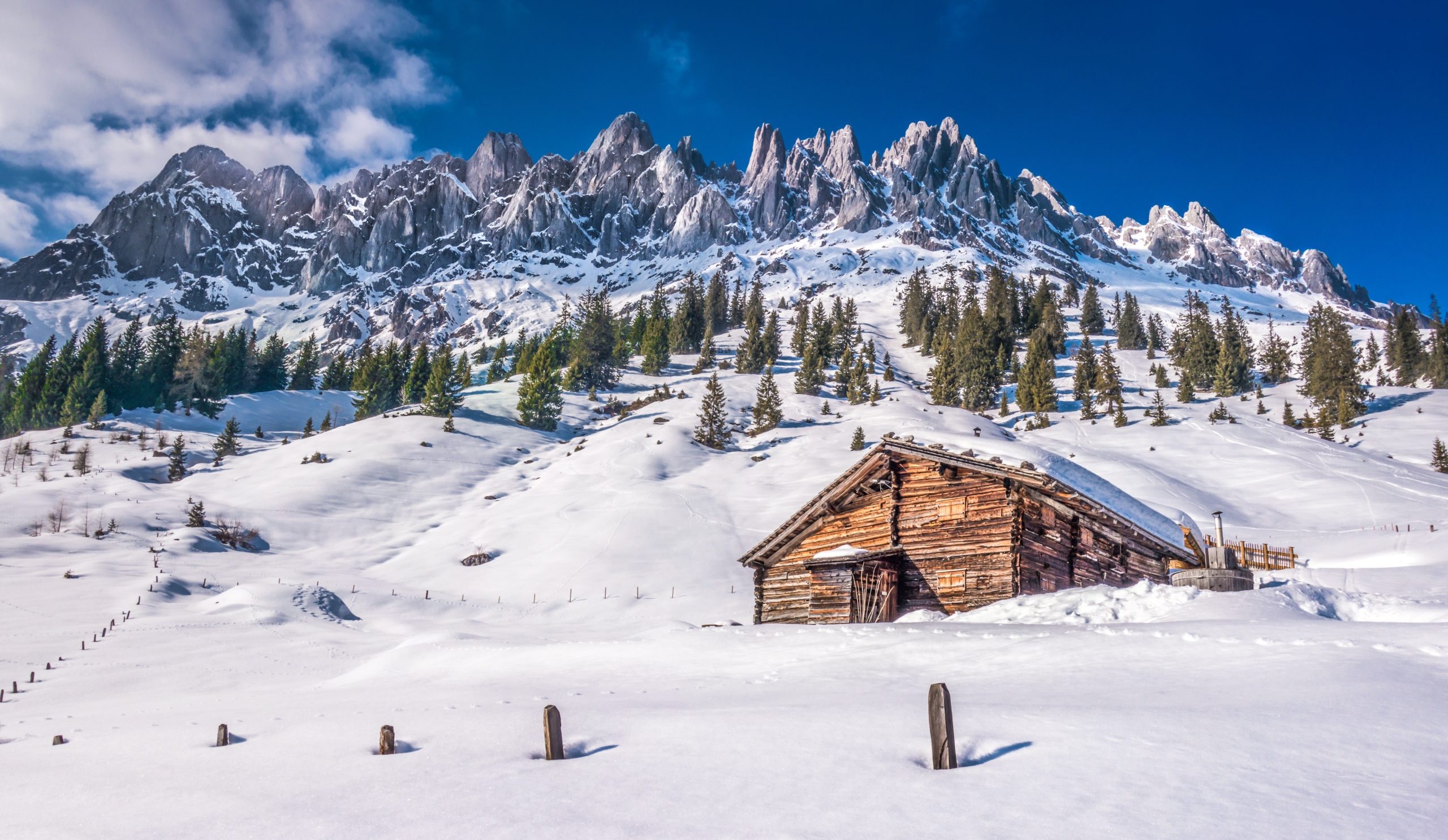 Idyllic winter wonderland scenery with traditional mountain chalet in the Alps